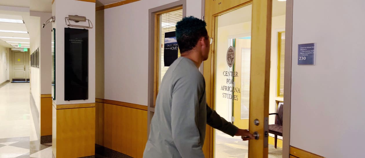 Student opening door to Center for Africana Studies offices in Mergenthaler Hall.