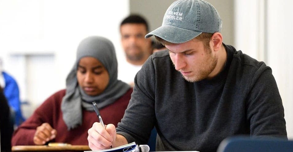 two students writing on desks