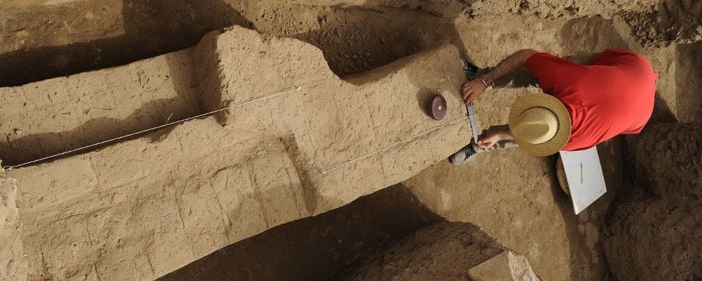 student measures an area of an excavation site in Luxor, Egypt