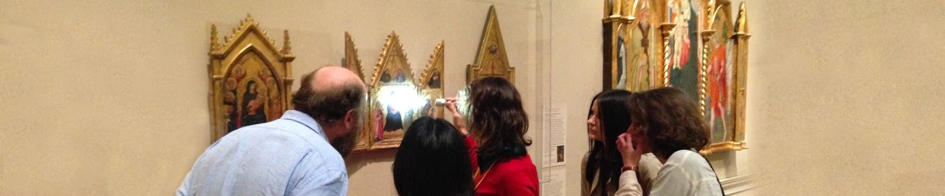 Graduate students in Image, Theory, Matter in Medieval Visual Culture seminar, examining a painting at the Walters Art Museum