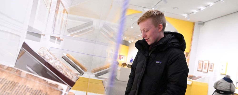 Student looking over a museum display.