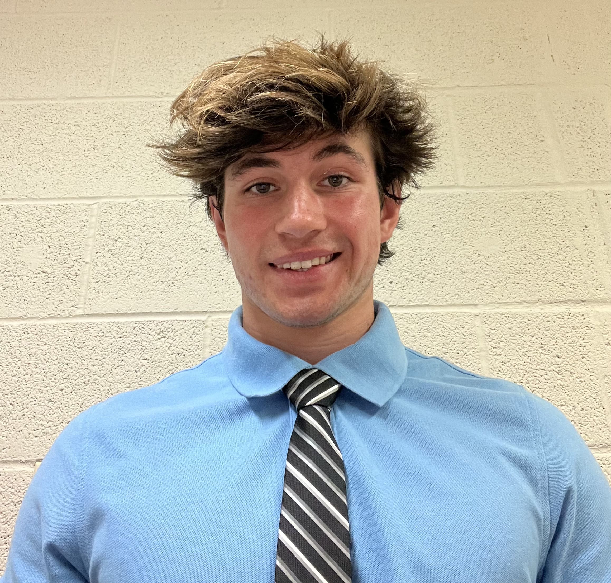 Smiling student in a blue shirt with a striped tie