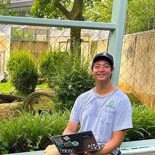 Alex Geffords in front of a zoo enclosure