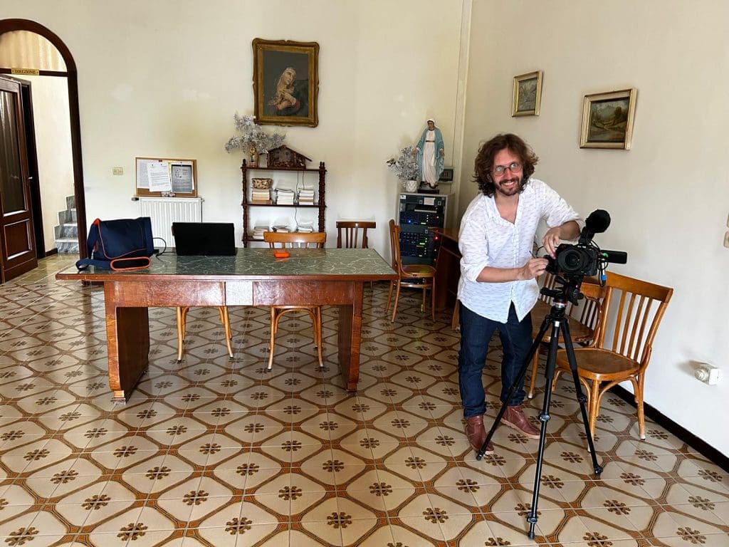 picture of man leaning on chair in room with tiles