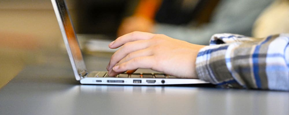 close up of hands typing on laptop