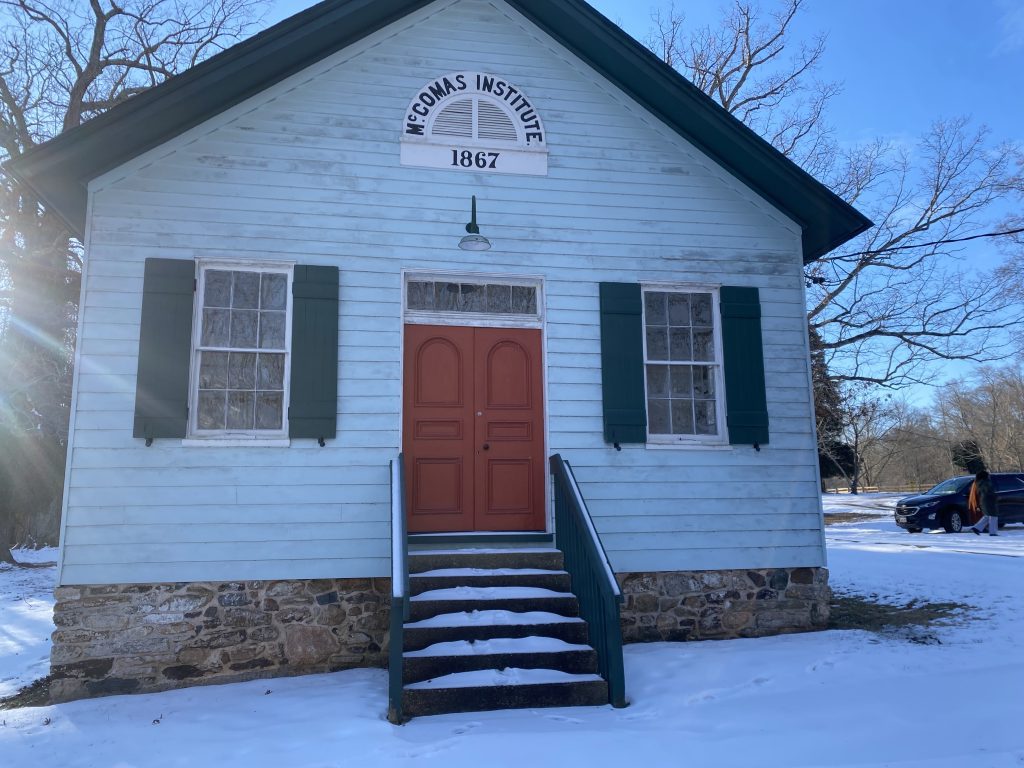 McComas Institute building with white walls and red door