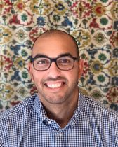 Man with glasses and checked shirt against flowery background