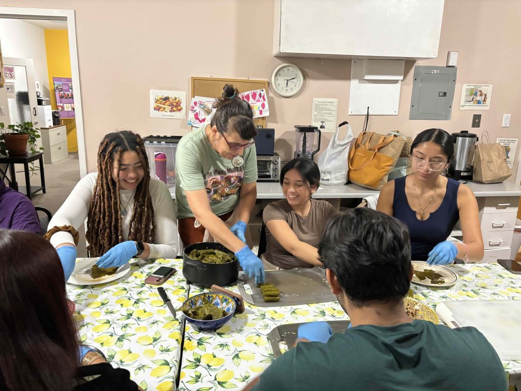 Students at table making food.