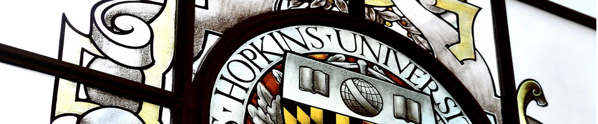 stained glass window with JHU seal