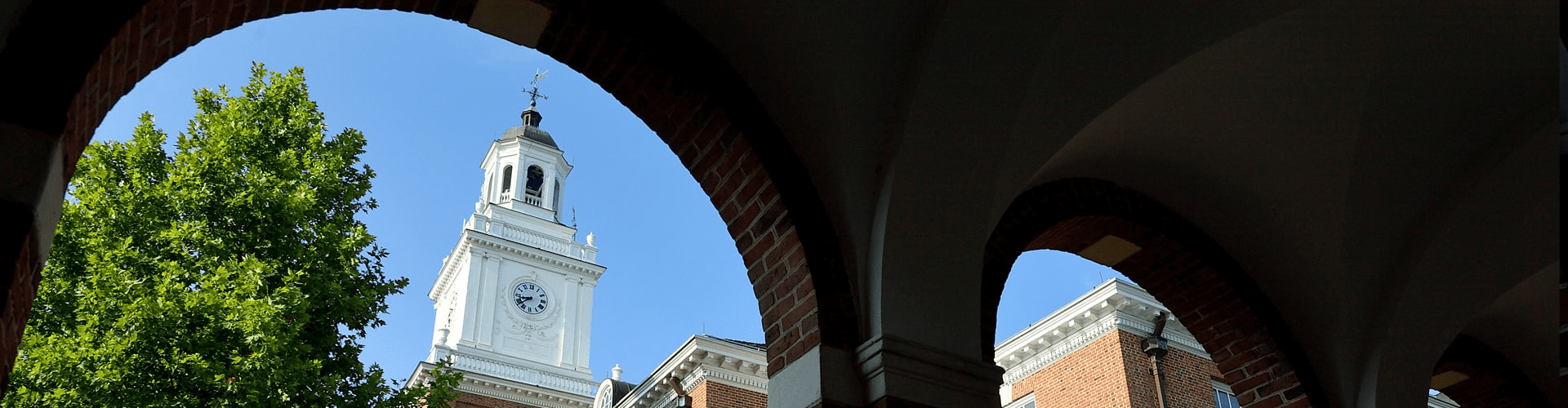 The Gilman Hall cupola through a brick archway
