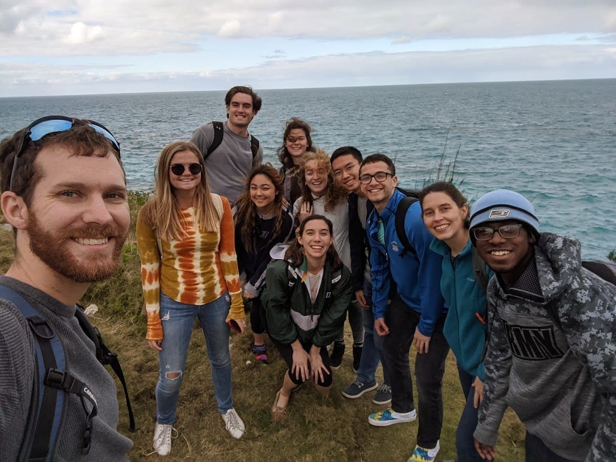 group of students in Bermuda standing in front of the coast