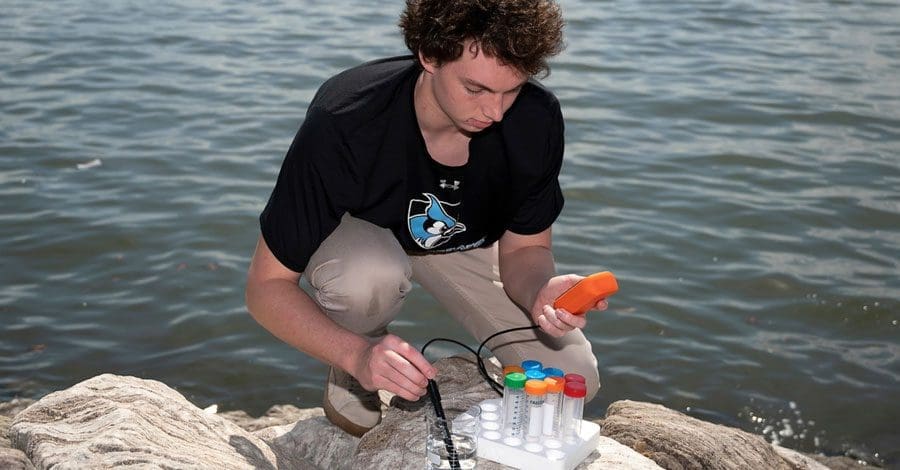 undergrad taking water samples from the Baltimore Harbor