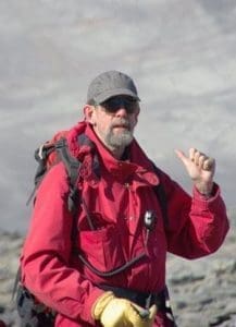 Bruce Marsh on a mountain in a red coat