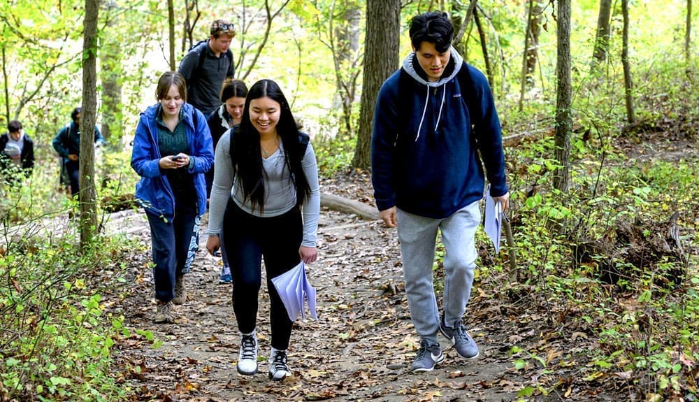Students walking in woods during Gambrills State Park field trip.
