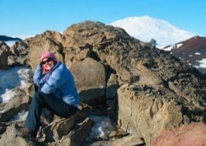 Person sitting among rocks covered in snow