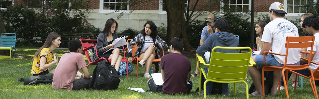 students working in colorful chairs outdoors on campus