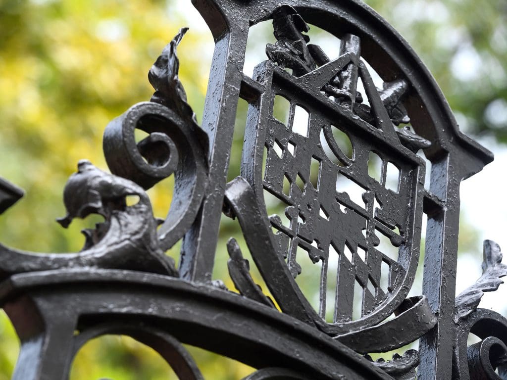 jhu shield on a wrought iron fence