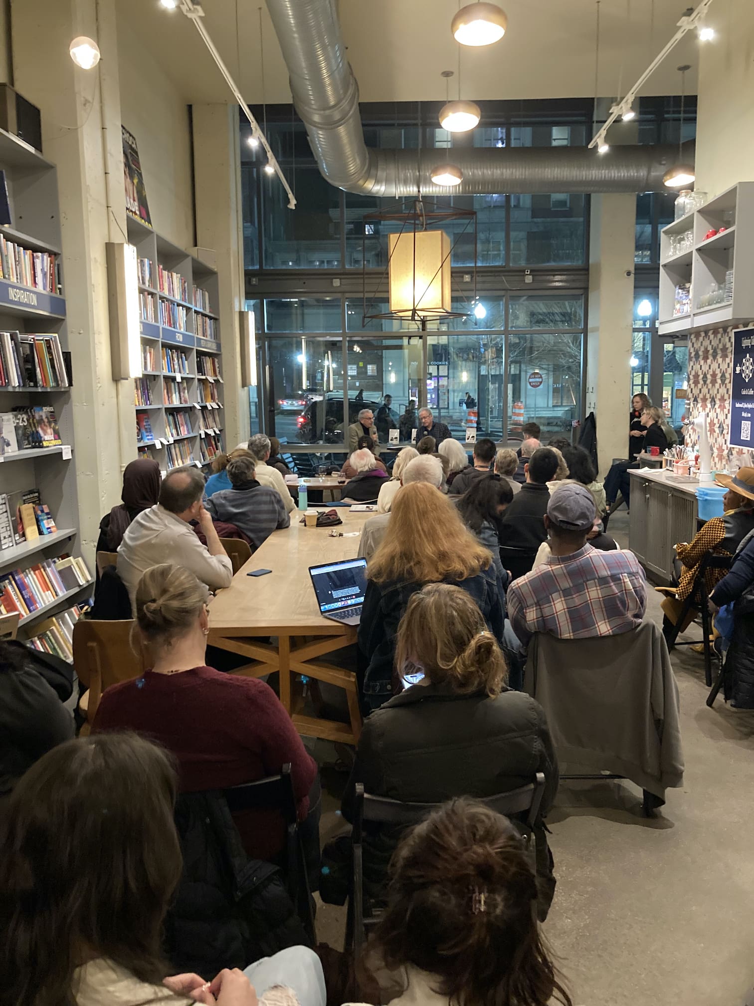 group of seated people in a bookstore listening to a speaker