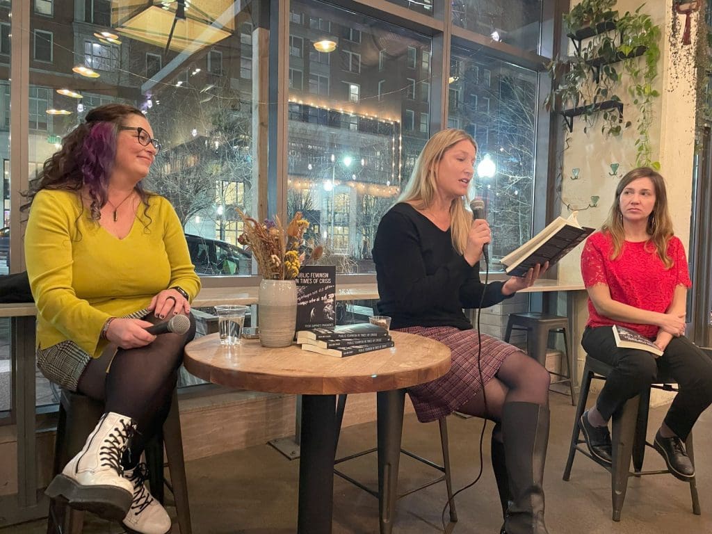 Leila, Dora and Jennifer in conversation. Jennifer is holding the microphone