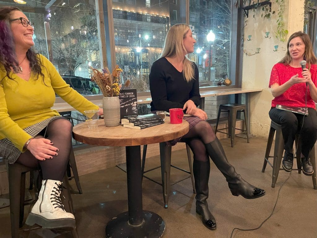 Leila, Dora and Jennifer in conversation. Dora is holding the microphone