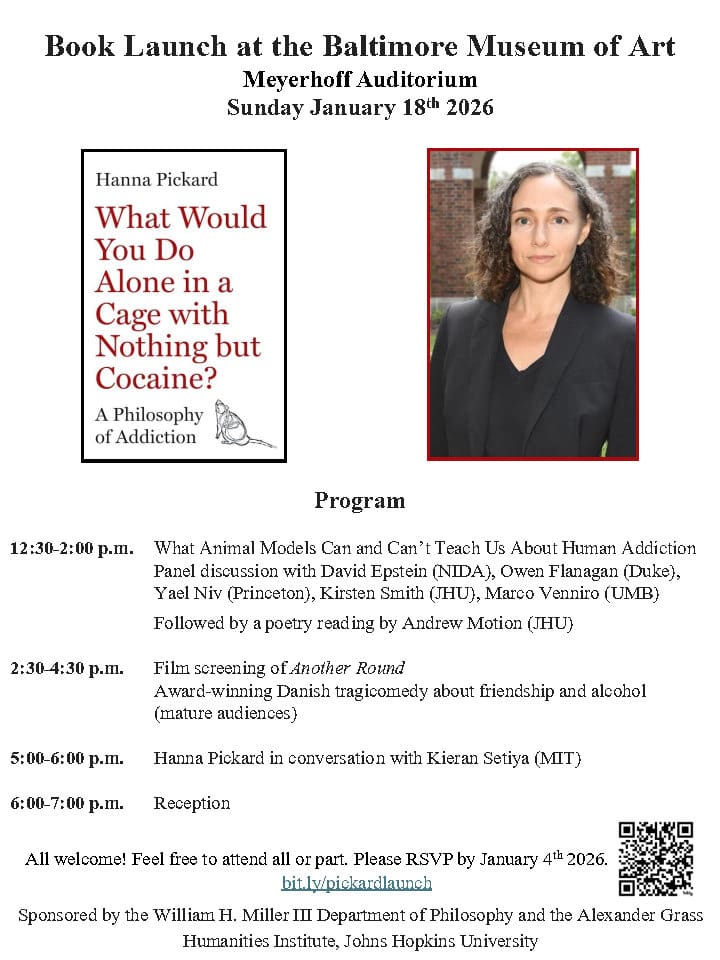 A person in a suit standing in front of a brick building