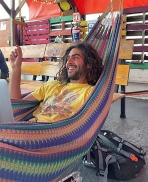 Kia in a hammock smiling wearing a yellow shirt