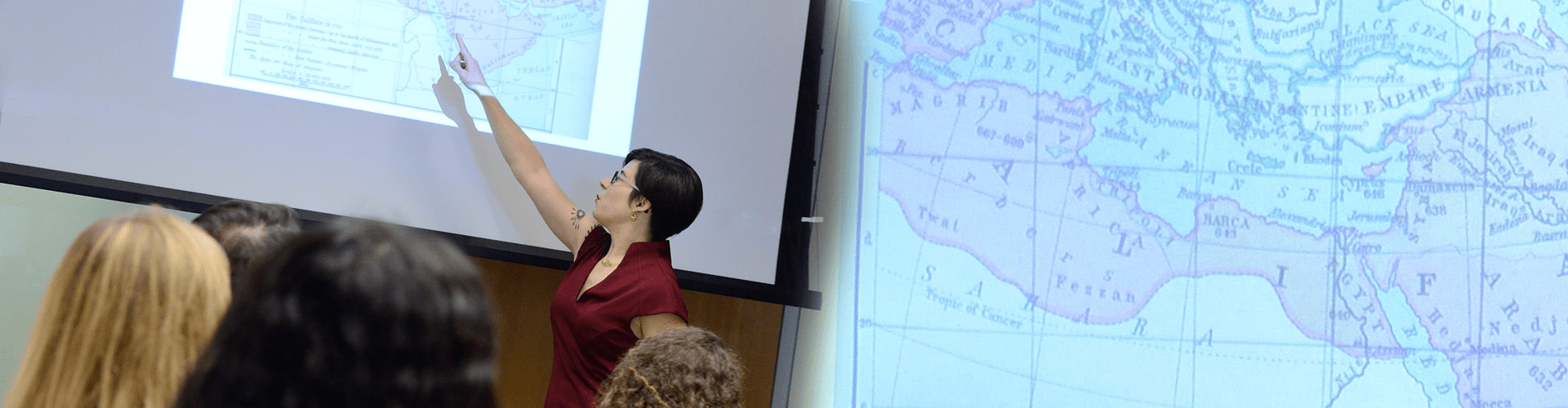 Faculty member pointing to a map projected on a screen