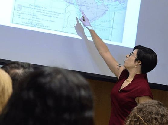 Faculty member pointing to a map projected on a screen