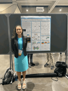 Student Alma Plaza-Rodriguez stands in front of the poster she made and presented at the 2023 Biophysical Society Meeting.