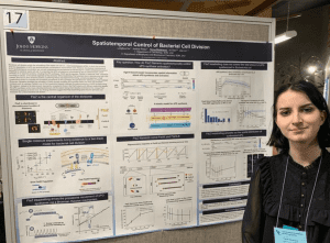 Tanya Nesterova in front of a research poster on Spatiotemporal Control of Bacterial Cell Division