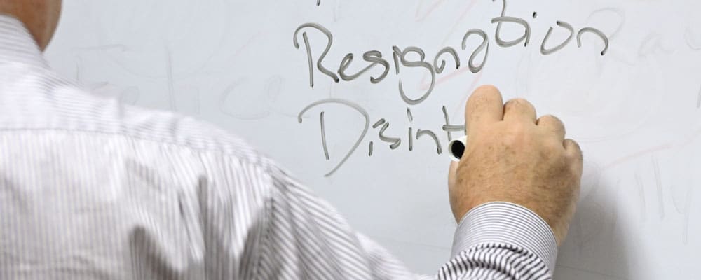 Faculty writing on a whiteboard.