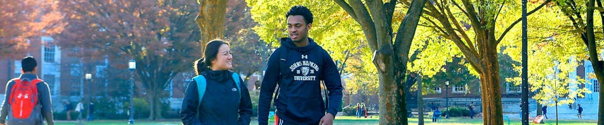 two students walking outdoors on campus