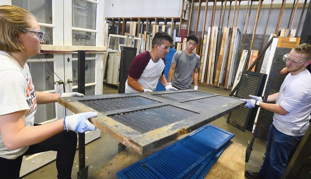 As part of pre-orientation community service activities, students stack doors at Second Chance Baltimore, where salvaged materials and products are made available to the public for reuse.