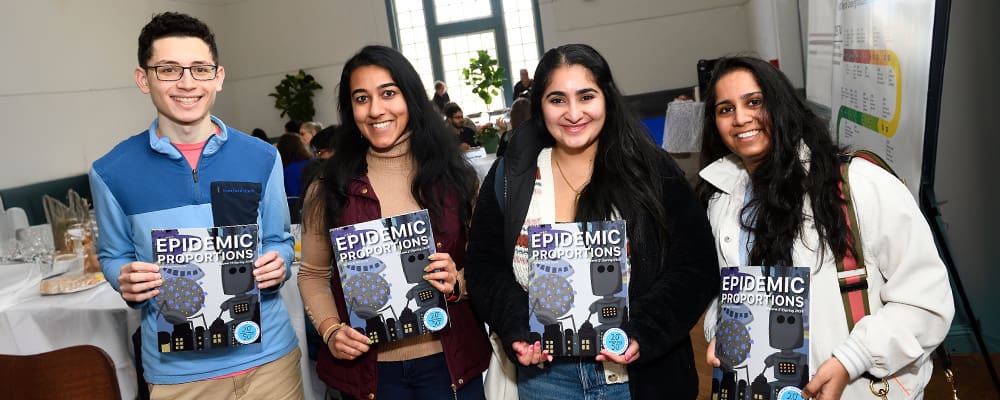 Four students holding up the latest issue of Epidemic Proportions.