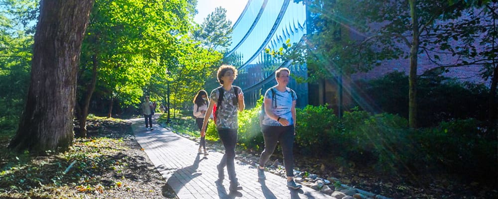 Students walking outdoors in front of the undergraduate teaching lab building on Homewood campus.