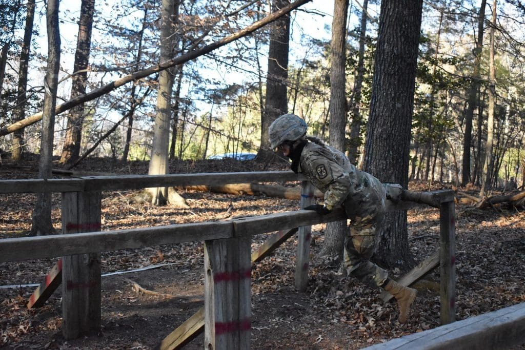 cadet climbing over wooden fences