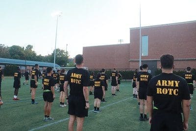 group of people in Army ROTC shirts on sports field
