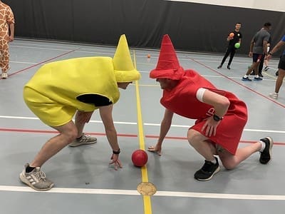 people dressed as ketchup and mustard kneeling down in front of a ball
