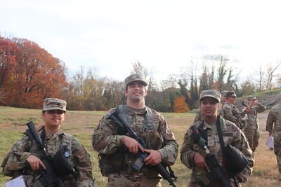 group of cadets outside in a field with autumn leaves