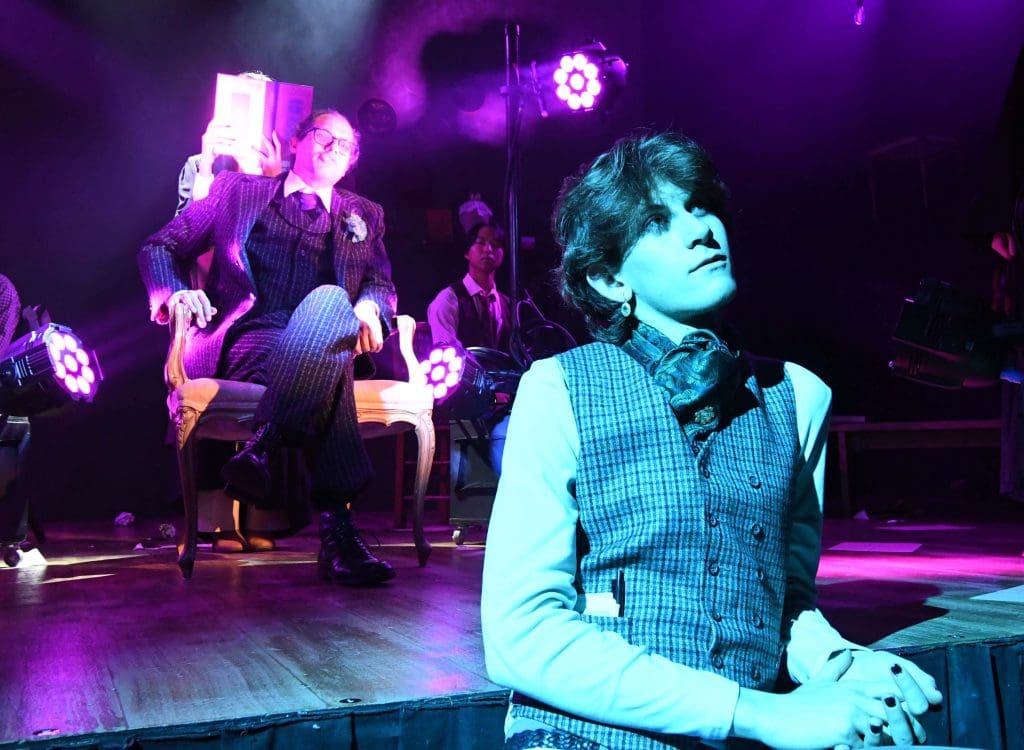 Lord Alfred Douglas, with Oscar Wilde in background.