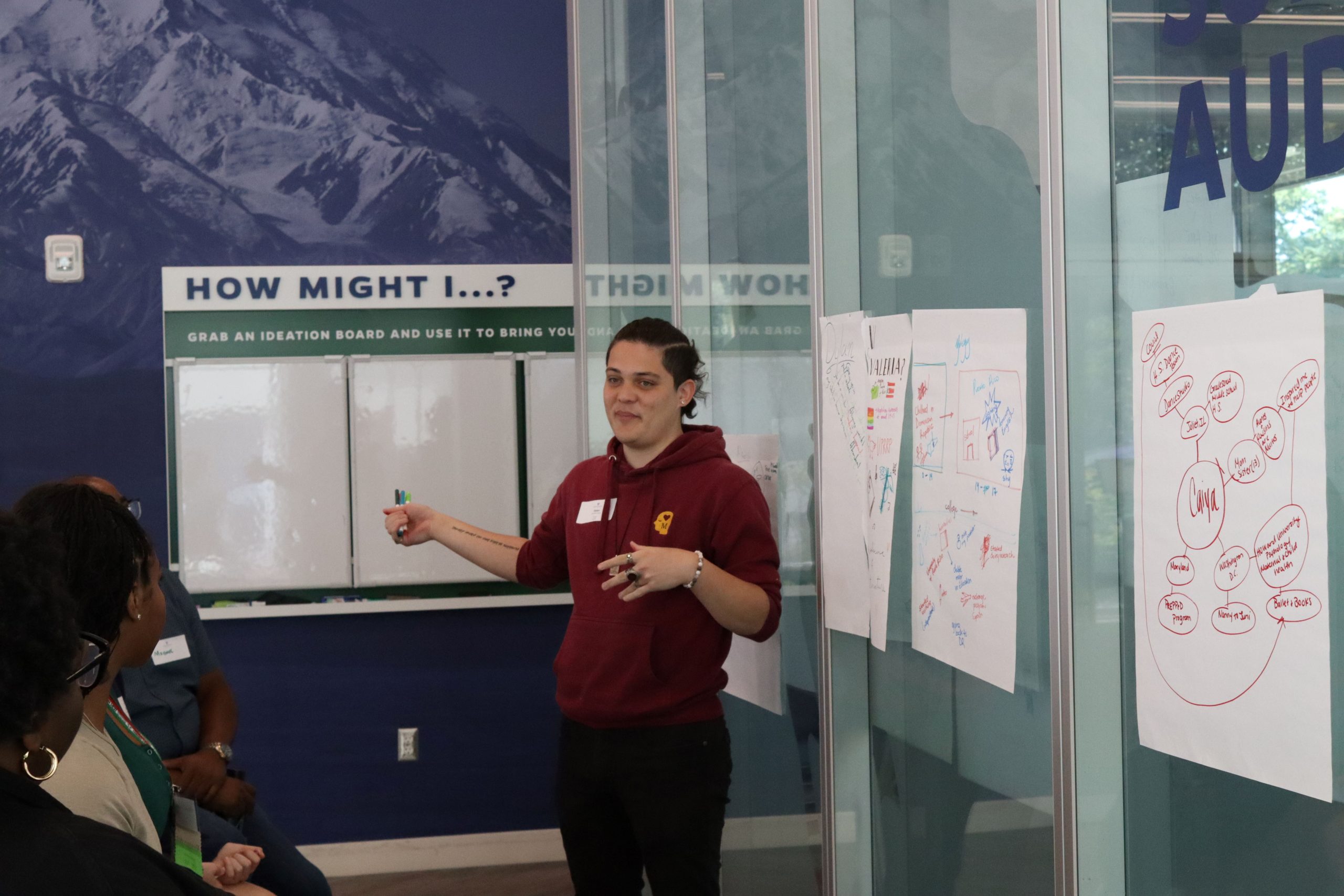 Dylan, a PATHS student, standing in front of a whiteboard presenting