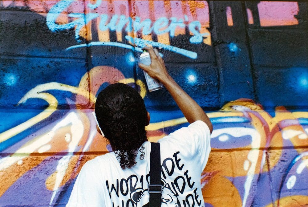 a person painting Grunners on a wall
