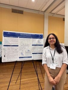 Suhani Aggarwal stands with their research poster