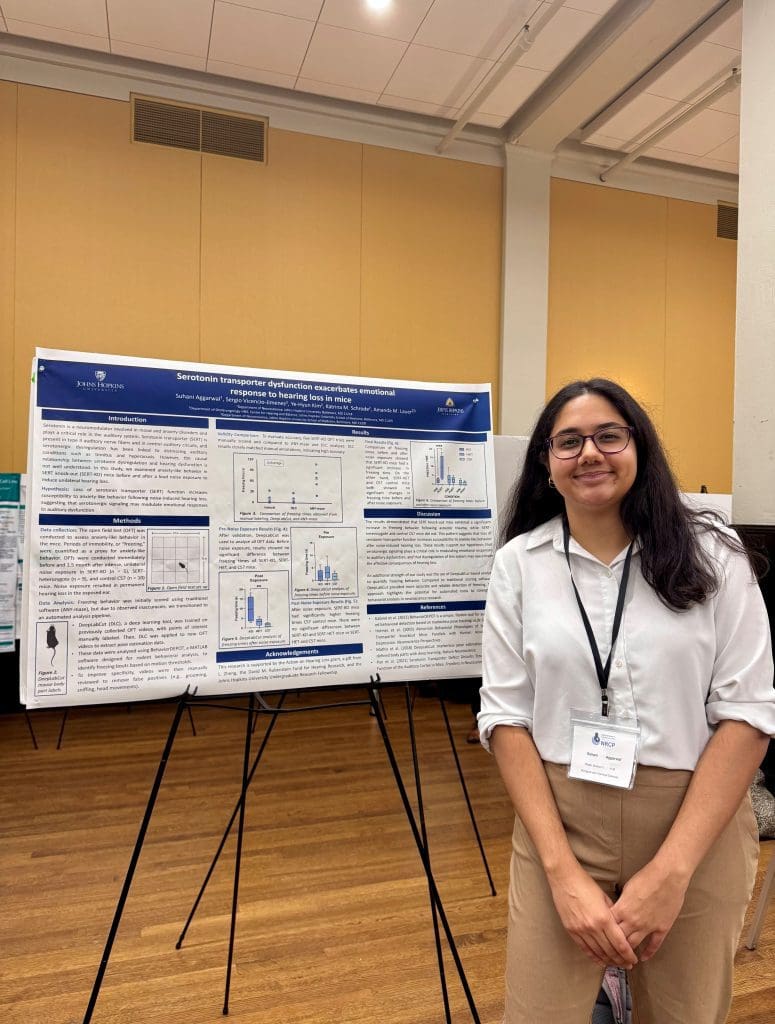 Suhani Aggarwal stands with their research poster