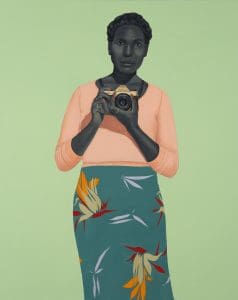 a painting by Amy sherald off a woman with dark hair and braids holding a Pentax camera wearing a salmon colored long sleeve shirt and a floral patterned teal skirt on a green background