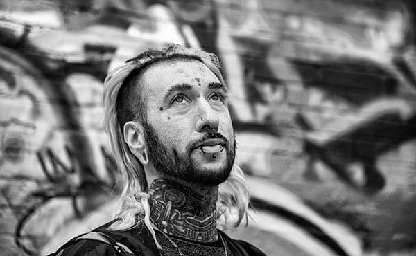 black and white photo of man with tattoos and long hair