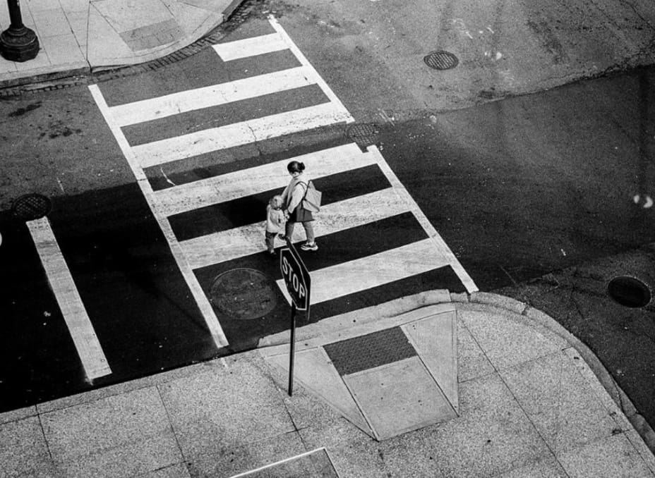 Photo of an adult and a child in a crosswalk from above