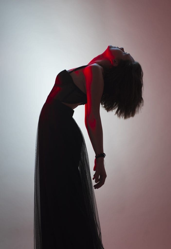 a woman bending backwards in front of a white background