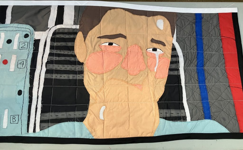 paneled quilt with a patchwork images of a man crying