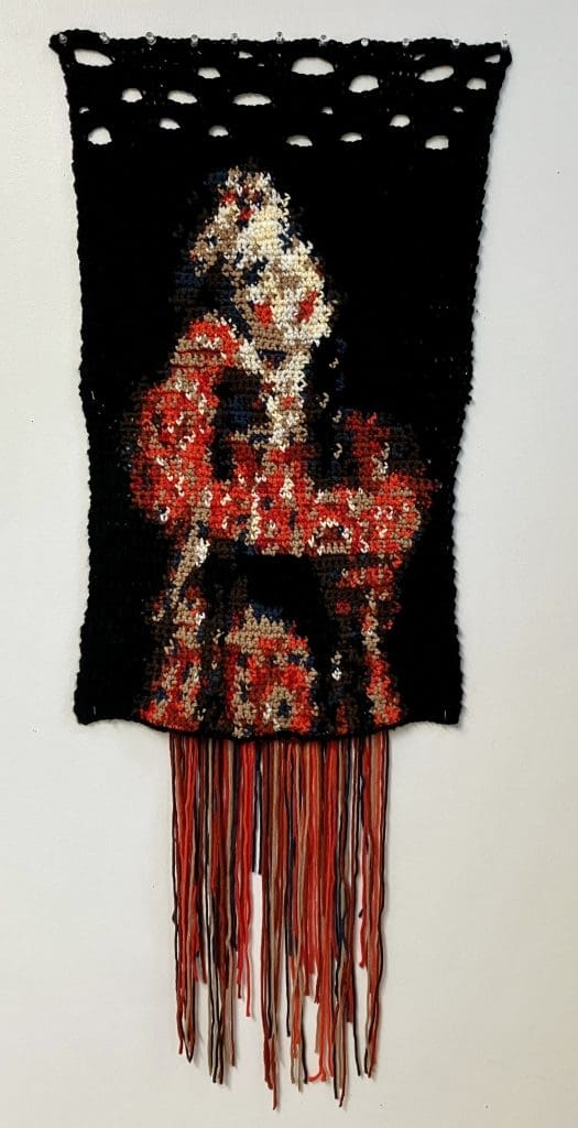 knitted 2d image of a women with her hand resting on her chin